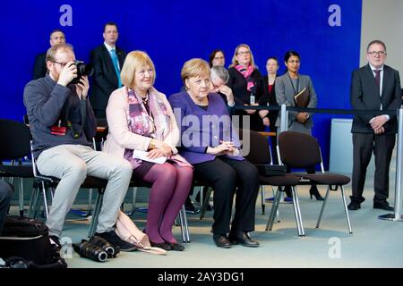 Berlin, Deutschland. Februar 2020. Bundeskanzlerin Angela Merkel (CDU, M) und Bettina Hagedorn (SPD, 2. Von links), Parlamentarische Staatssekretärin im Bundesfinanzministerium, sitzen neben einem Fotografen bei der Präsentation der aktuellen 2-Euro-Gedenkmünze "Brandenburg" im Bundeskanzleramt. In diesem Jahr würdigt die 2-Euro-Sondermünze das Land Brandenburg. Credit: Christoph Soeder / dpa / Alamy Live News Stockfoto