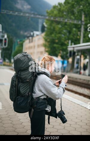 Frau mit Handy am Bahnhof Stockfoto