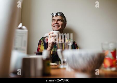 Lächelnder Mann am Tisch Stockfoto