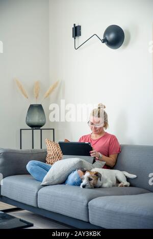 Frau auf Sofa mit digital-Tablette Stockfoto