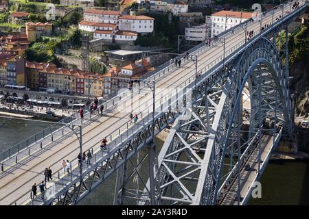 Hoher Winkel und Teilblick auf die Brücke D.Luis I in Porto, wo Fußgänger im Hintergrund mit einem Teil der Altstadt überfahren werden können Stockfoto