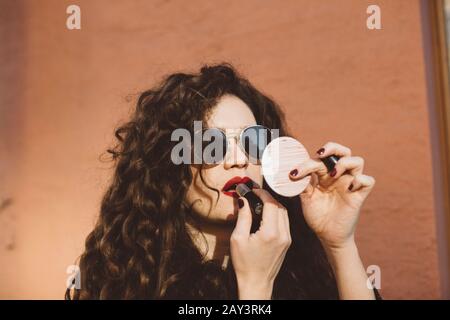 Frau Auftragen von Lippenstift Stockfoto