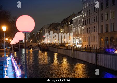 Berlin, Deutschland. Februar 2020. Die rot leuchtenden Lichter einer Gaststätte auf der Fischerinsel an der Roßstraßenbrücke führen am Spreekanalufer. Auf der anderen Seite, am Märkischen Ufer, ist das Ermeler Haus etwas heller beleuchtet. Im Hintergrund beginnt der Museumshafen an der Roßstraßenbrücke. Kredit: Soeren Stache / dpa-Zentralbild / ZB / dpa / Alamy Live News Stockfoto