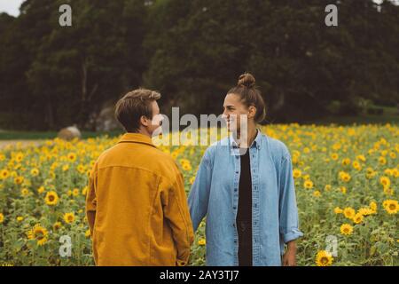 Paar auf dem blühenden Sonnenblumenfeld Stockfoto