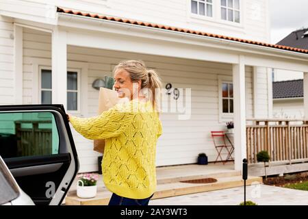 Frau vor Haus Stockfoto