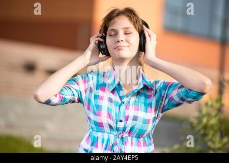 Junges, wunderschönes Mädchen, das auf der Straße Musik hört. Stockfoto