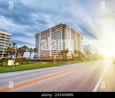 Sonnenuntergang in Boca Raton, Florida. Straße, Bäume und Gebäude. Stockfoto