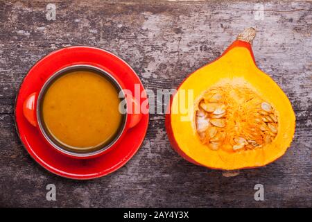 Kürbissuppe und halb Hokkaido auf Holz Stockfoto