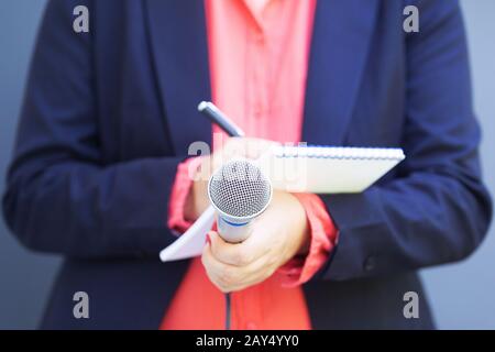 Journalistin bei der Pressekonferenz, das Schreiben von Noten, Mikrofon Stockfoto