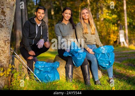 Weibliche Freiwillige sammeln Müll auf Gras Stockfoto