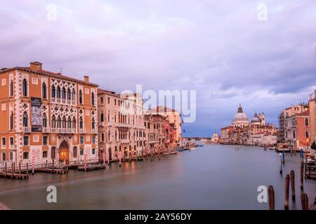 Blick auf den Canal Grande bei Sonnenuntergang von der Accademia-Brücke mit der Basilika Santa Maria della Salute und Punta della Dogana. Venedig. Italien Stockfoto