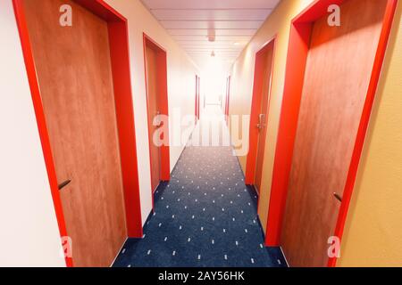 Leerer Hotelflur mit Türreihe Stockfoto