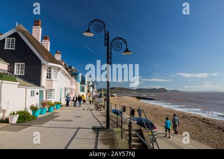 Eine bunte Reihe von Häusern und Ammoniumlampenpfosten an der Meeresfront in Lyme Regis an der Jurassic Coast, Dorset, England, Großbritannien Stockfoto