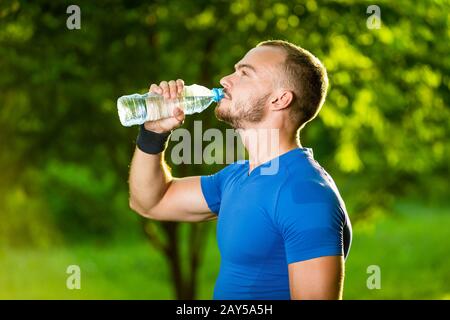 Sportlicher reifen Mann Trinkwasser aus der Flasche Stockfoto