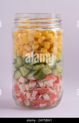 Heller Regenbogensalat aus Mais, Gurken und Krabbenstäbchen. Trends beim gesunden Essen. Selektiver Fokus. Stockfoto