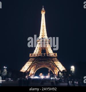 Der wundervolle Pariser Eiffelturm glänkt gegen den Nachthimmel. Touristenattraktionen in Europa und der Welt Stockfoto