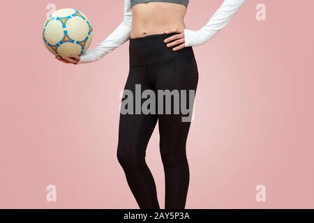 Nahaufnahme einer Frau, die Beinkleider trägt, die ein Fußball-, Sporteignungkonzept hält. Stockfoto