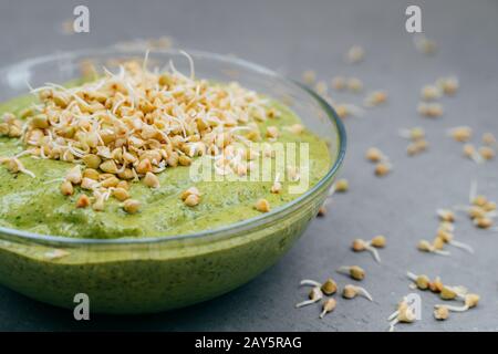 Glasschale aus grünem frischen Smoothie aus biologischem Gemüse mit gerouttem Buchweizen. Gesundes, sauberes Essenskonzept. Rohprotein Stockfoto
