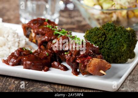 Shashlik-Spieße mit Brokkoli auf einem weißen Teller Stockfoto