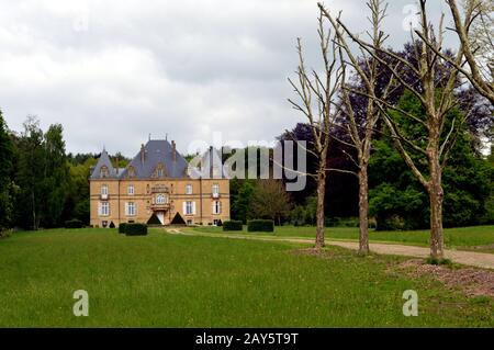 Ehemalige Burg im Wald mit einem Weg von Bäumen und eine große Liegewiese. Stockfoto