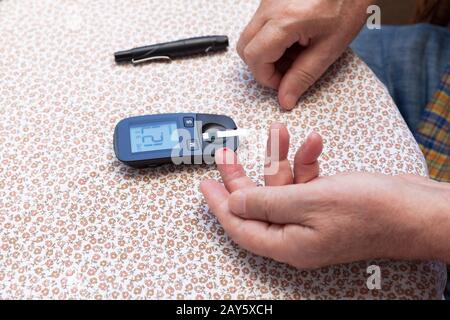 Blutzuckermessung am Finger Stockfoto