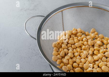 Organische Samen im Sieb. Trockene Kichererbsen für eine gesunde Ernährung. Overhead-Ansicht. Nährstoffdichte Nahrung. Garbanzobohnen enthalten viel Protein Stockfoto