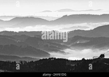 Blick auf den nördlichen zentralen Schwarzwald Richtung Feldberg im nebligen Winter schwarz-weiß Stockfoto