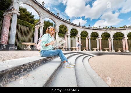 30. Juli 2019, Versailles, Frankreich: Frau liest Karte im Gebäude Colonnade im königlichen Garten Stockfoto