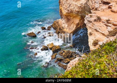 Draufsicht über die Landschaft Blick auf Felsen, Klippen, Meereswellen an der Algarve, Lagos, Portugal. Möwe auf einer Klippe im Atlantik. Wasser in Co. Spritzt Stockfoto