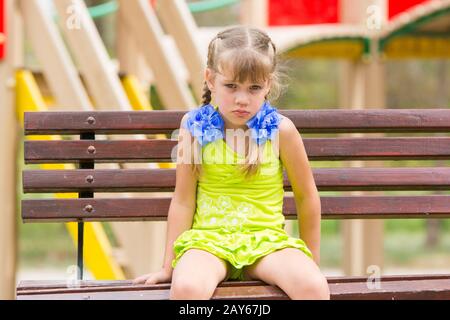 Beleidigt fünf Jahre altes Mädchen sitzen auf einer Bank am Spielplatz Stockfoto