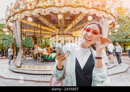 Asian Woman mit Smartphone in der Nähe von Carousel in paris Stockfoto