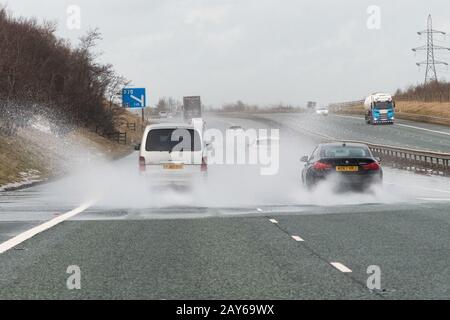 M74 in der Nähe von Uddington, Lanark, Schottland, Großbritannien. Februar 2020. Wetter in Großbritannien - Fahrzeuge, die auf der M74 in Richtung Norden in der Nähe von Uddington, Lanark, Schottland, Großbritannien in ein tief gehendes Oberflächenwasser eindringen. Der Sturm Dennis wird morgen zu Reiseunterbrechungen mit starkem Wind und starkem Regen führen. Gutschrift: Kay Roxby/Alamy Live News Stockfoto