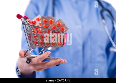 Arzt mit Einkaufswagen voller Pillen isoliert auf weiss Stockfoto