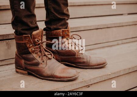 Bild von bemannt braunes Schuhwerk, das auf Holzstufen steht. Mann in Hose und rasige Schuhe an der Schwelle. Horizontale Ansicht Stockfoto