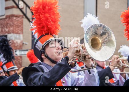 8-28-2019 Tahlequah USA - Junger Mann in Uniform spielt begeistert die Posaune in einer High-School-Marching Band-Parade mit anderen Bandmitgliedern blurr Stockfoto