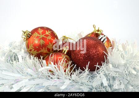 Fünf Christbaumkugeln ruhen in einem weißen Nest. Stockfoto