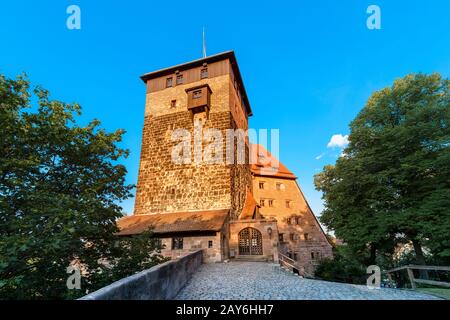 Blick auf den hohen Turm der Kaiserlichen Burg Nürnberg bei Sonnenuntergang Stockfoto