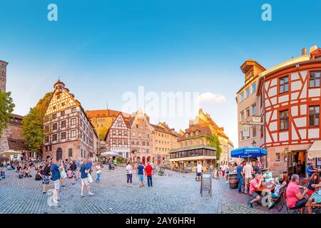 August 2019, Nürnberg, Deutschland: Touristen entspannen sich in Restaurants und Tavernen auf dem schönen Platz in der Altstadt von Nürnberg Stockfoto