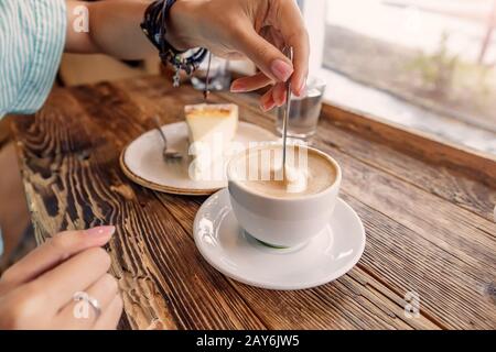 Porträt der schönen asiatischen Frau, die Kaffee im Retro-Café in der Nähe des Fensters trinkt Stockfoto