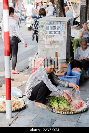 Vietnamesische Straßenhändler handeln und verkaufen ihre Gemüse- und Obstprodukte in Hanoi, Vietnam Stockfoto