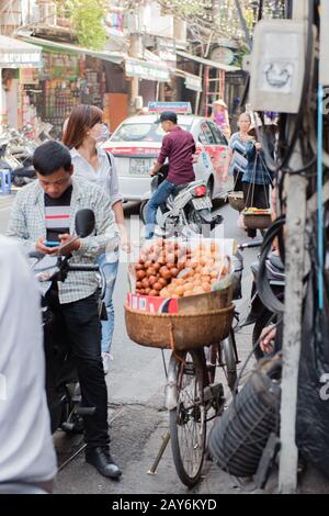 Vietnamesische Straßenhändler handeln und verkaufen ihre Gemüse- und Obstprodukte in Hanoi, Vietnam Stockfoto