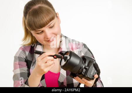 Fotograf-Bürste reinigt die Vorderseite des Objektivs auf die Kamera Stockfoto