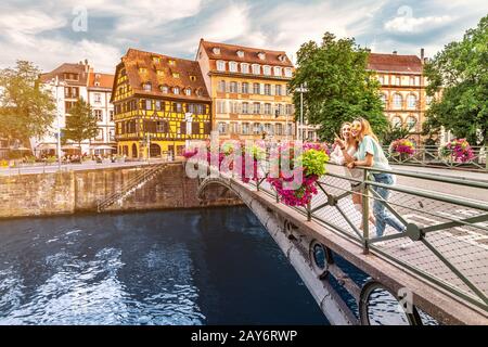 Zwei junge glückliche Mädchen-Freunde, die auf einer Brücke in Straßburg stehen, während sie in der Region Petit France unterwegs sind. Tourismus- und Freundschaftskonzept Stockfoto