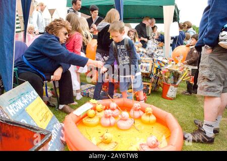 Kleiner Junge, der auf einer lokalen Fete/Messe "Hook-a-Duck" spielen wird Stockfoto