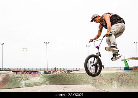 Junger Mann springt mit einem BMX-Fahrrad im Skatepark in Playa Brava. Iquique, Region Tarapaca, Chile. Stockfoto