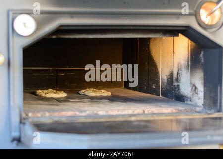 Pizza in einem alten Ofen - Nahansicht in einen großen offenen Ofen Stockfoto