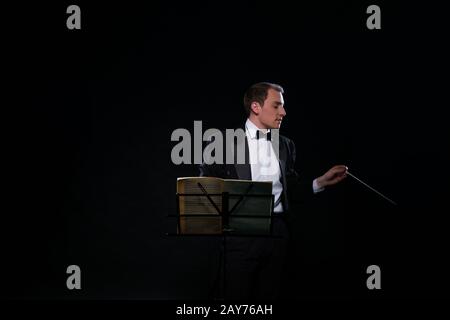 Dirigent im schwarzen Smoking in dunklen studio Stockfoto