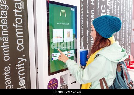 03. Mai 2019, Moskau, Russland: Frau bestellt Mahlzeit im elektronischen Touchscreen Terminal-Menü im Fastfood-Restaurant Burger King Stockfoto