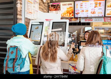 03. Mai 2019, Moskau, Russland: Frau bestellt Mahlzeit im elektronischen Touchscreen Terminal-Menü im Fastfood-Restaurant Burger King Stockfoto