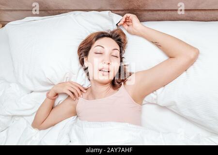 Asian Woman schläft entspannt auf einem großen, geräumigen Bett zu Hause oder in einem Hotel Stockfoto